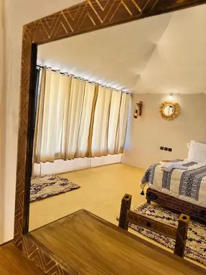 a mirror reflection of a bedroom with a bed in it at Sahara Moon Camp in Merzouga