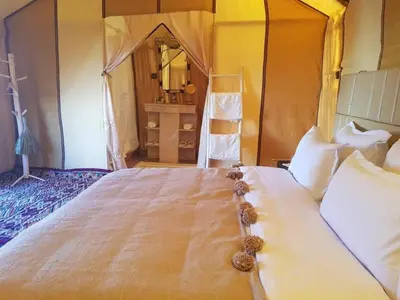 a bedroom with a large bed with a large mirror at Sahara Moon Camp in Merzouga
