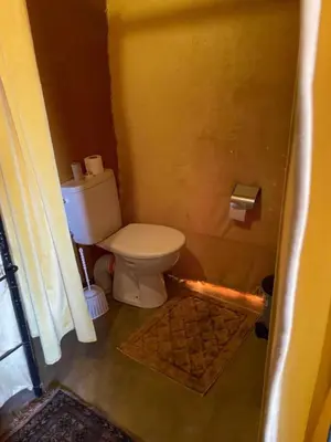 a bathroom with a toilet in a room at Sahara Moon Camp in Merzouga
