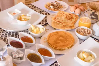 a table topped with pancakes and other breakfast foods at Sahara Moon Camp in Merzouga