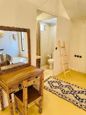 a dressing room with a mirror and a dressing table at Sahara Moon Camp in Merzouga