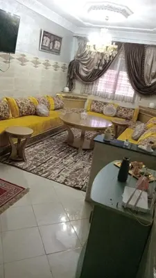 a living room with a couch and a table at Appartement Conviviable Et Chaleureux in Oulad Akkou