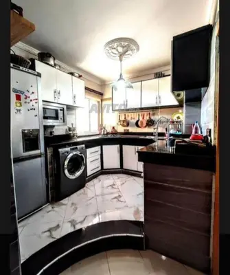a large kitchen with a washer and dryer in it at Appartement Conviviable Et Chaleureux in Oulad Akkou