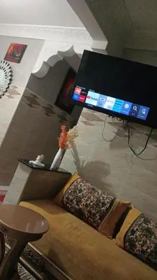 a living room with a couch and a tv at Appartement Conviviable Et Chaleureux in Oulad Akkou