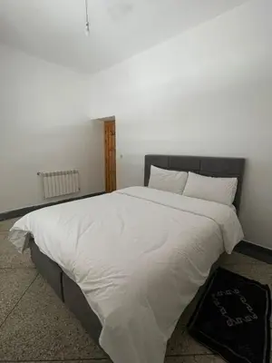 a bedroom with a large bed with white sheets at Apartment amina in Azrou