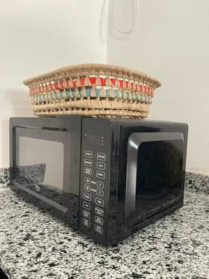 a basket on top of a microwave on a counter at Apartment amina in Azrou