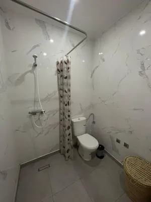 a white bathroom with a toilet and a shower at Apartment amina in Azrou