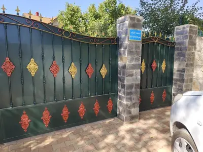 a black fence with a gate with red and gold decorations at appartement lamia in Azrou