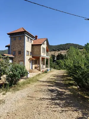 a large stone house on a dirt road at appartement lamia in Azrou