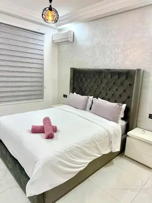a large white bed with a pink towel on it at Charmant appartement meublé avec Wifi Fibre 100Mo in Fès