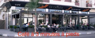 a restaurant with people sitting at tables outside of it at Charmant appartement meublé avec Wifi Fibre 100Mo in Fès
