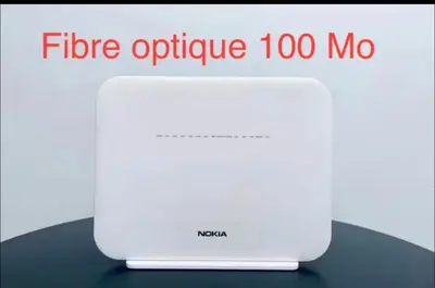 a white router sitting on top of a table at Charmant appartement meublé avec Wifi Fibre 100Mo in Fès