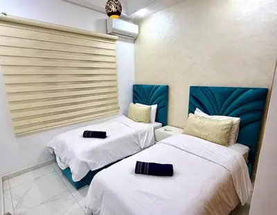 two beds in a room with white and blue at Charmant appartement meublé avec Wifi Fibre 100Mo in Fès
