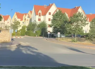 an empty street with a large building with red roofs at Cozy & Affordable Family Apartment for married couples only in Ifrane