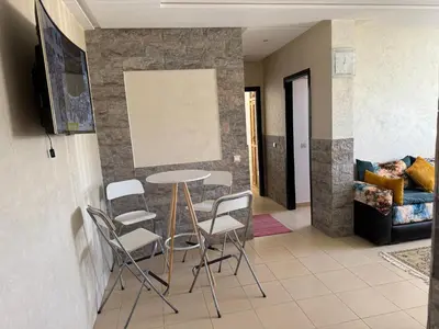 a living room with a table and chairs at Cozy & Affordable Family Apartment for married couples only in Ifrane