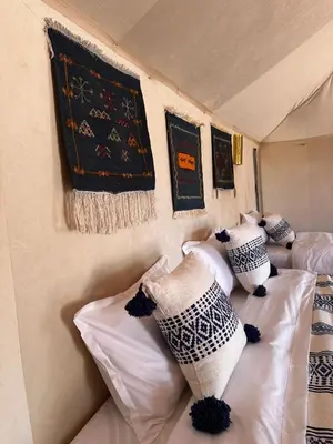 two beds in a room with pillows on them at ALQADAR - Desert Lux Camp in Merzouga
