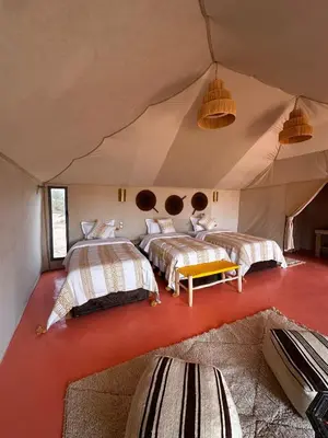 a bedroom with two beds in a tent at ALQADAR - Desert Lux Camp in Merzouga