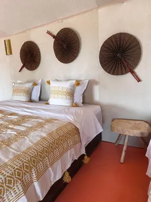 a bedroom with a bed and two hats on the wall at ALQADAR - Desert Lux Camp in Merzouga
