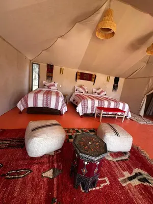 a room with three beds in a tent at ALQADAR - Desert Lux Camp in Merzouga
