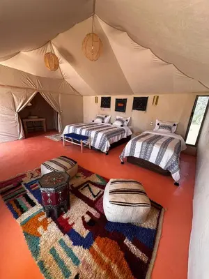 a room with two beds in a tent at ALQADAR - Desert Lux Camp in Merzouga