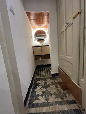 a hallway with a door and a tiled floor at Dar Latifa in Fès