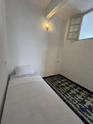 a bed in a room with a window at Dar Latifa in Fès