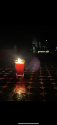 a red candle sitting on a table in the dark at Sahara Luxury Camp merzouga in Merzouga