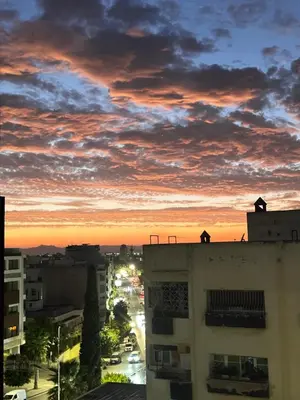 a person standing on top of a building at sunset at Apparemment fes la momie in Fès