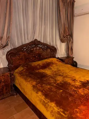 a bedroom with a large wooden bed with curtains at Apparemment fes la momie in Fès