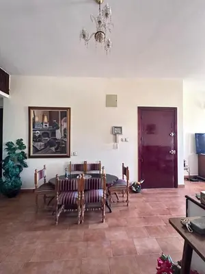 a living room with a table and chairs and a chandelier at Apparemment fes la momie in Fès