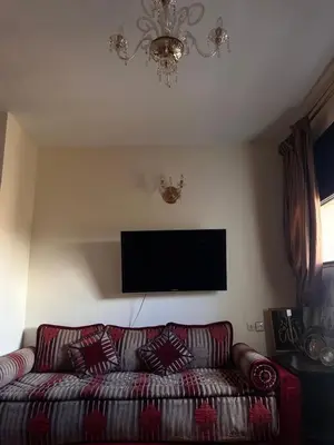 a living room with a couch and a flat screen tv at Apparemment fes la momie in Fès