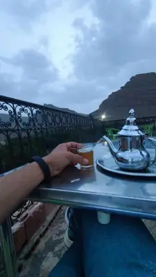 a person sitting at a table with a drink at Auberge baddou amougar in Amouguer