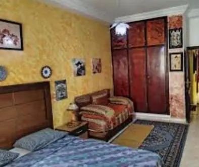 a bedroom with a bed and a chair and a couch at Hotel ouelfa in Oulad Akkou