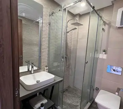 a bathroom with a sink and a glass shower at Hotel ouelfa in Oulad Akkou