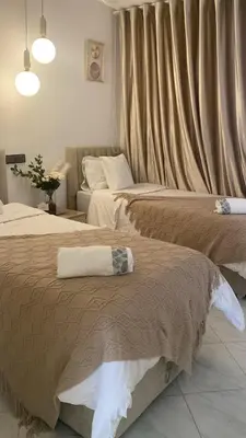 two beds in a hotel room with curtains and a pillow at شقة فخمة in Ifrane