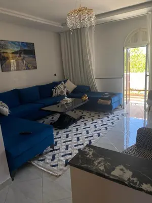 a living room with a blue couch and a table at شقة فخمة in Ifrane