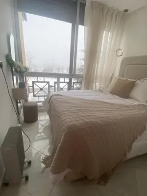 a bedroom with a bed and a large window at شقة فخمة in Ifrane