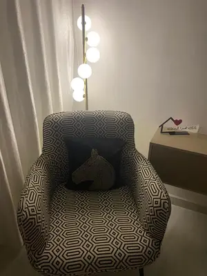 a chair with a pillow in a room with a table at شقة فخمة وهادئة in Ifrane