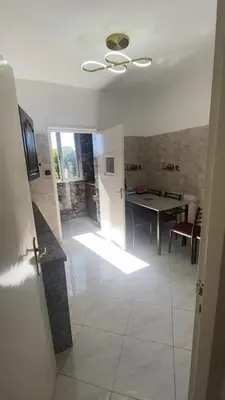 a living room with a table and a ceiling fan at شقة فخمة وهادئة in Ifrane