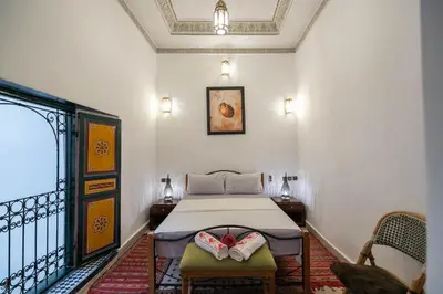 a bedroom with a bed and two chairs at Dar Alillouch in Fès