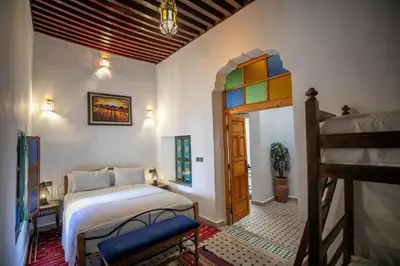 a bedroom with a bed and a ladder in a room at Dar Alillouch in Fès