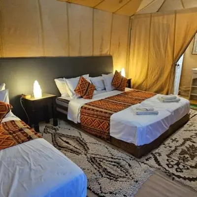 a hotel room with two beds and two lamps at Sahara serenity camp in Merzouga