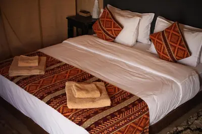 a bed with pillows and towels on it at Sahara serenity camp in Merzouga