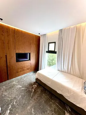 a bedroom with a bed and a tv on a wall at Rooftop avec Piscine privée - 2 chambres - Marrakech in Oulad Akkou