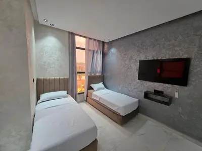 a bedroom with two beds and a flat screen tv at appartement moderne khenifra 2 in Khenifra