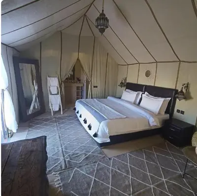 a bedroom with a large bed in a tent at Sahara Classic Luxury Camp in Merzouga