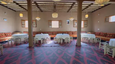 a large room with white tables and chairs in it at Nana Diafa - Zagora Guest House & Restaurant in Zagora