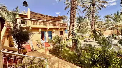 a house with palm trees in front of it at Nana Diafa - Zagora Guest House & Restaurant in Zagora