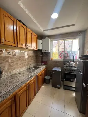 a kitchen with wooden cabinets and a stainless steel refrigerator at Stylish & Spacious Apartment in Peaceful Ifrane in Ifrane