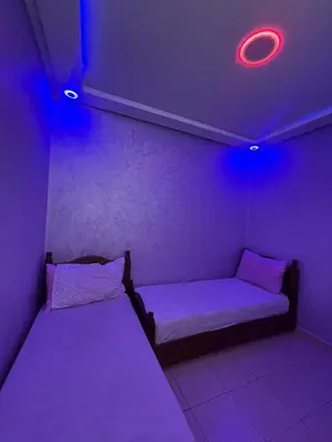 a room with two beds and a purple light at Stylish & Spacious Apartment in Peaceful Ifrane in Ifrane